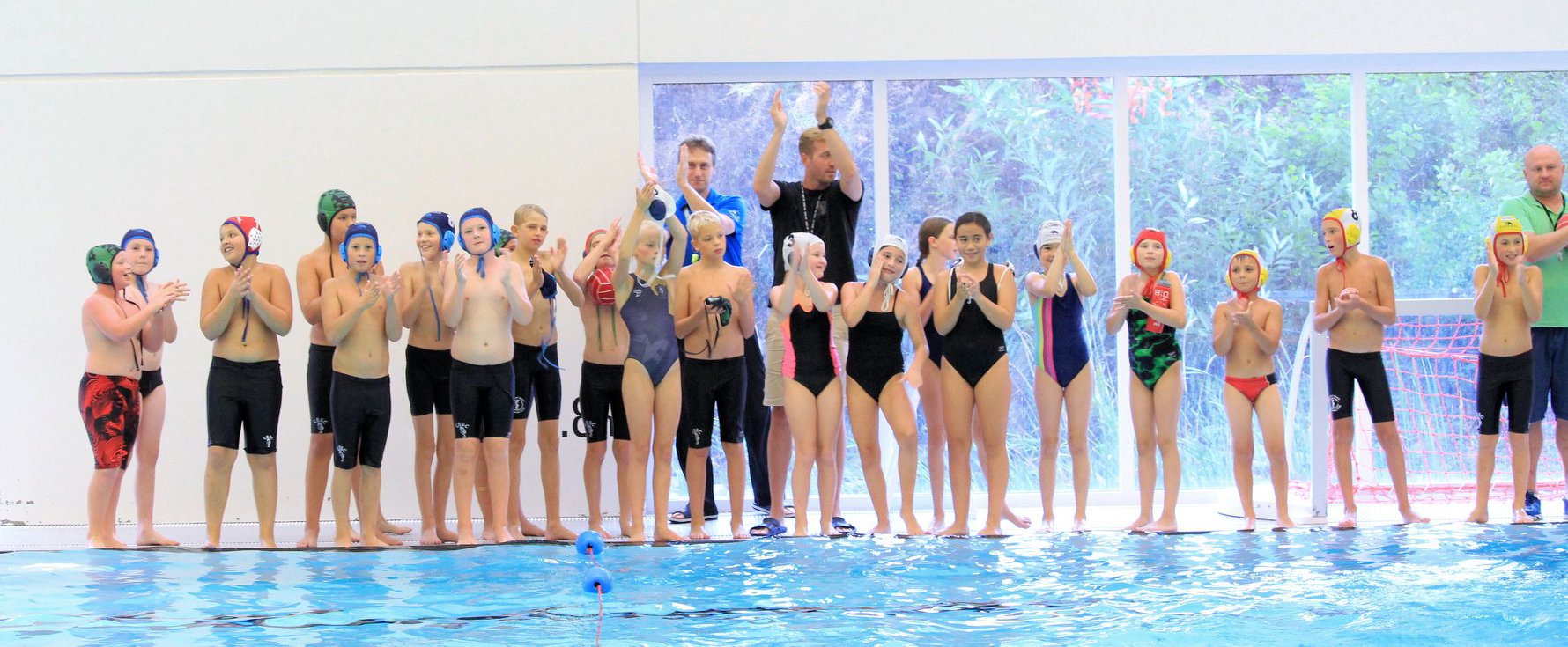 Younger Surrey Water Polo athletes with their coaches on the pool deck